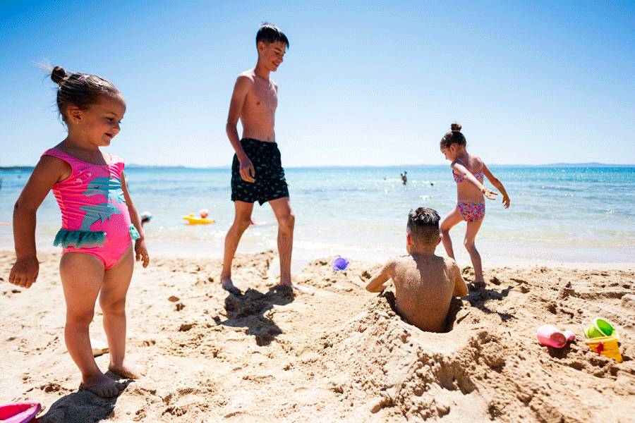 Enfants jouant sur une plage à Dubai en famille