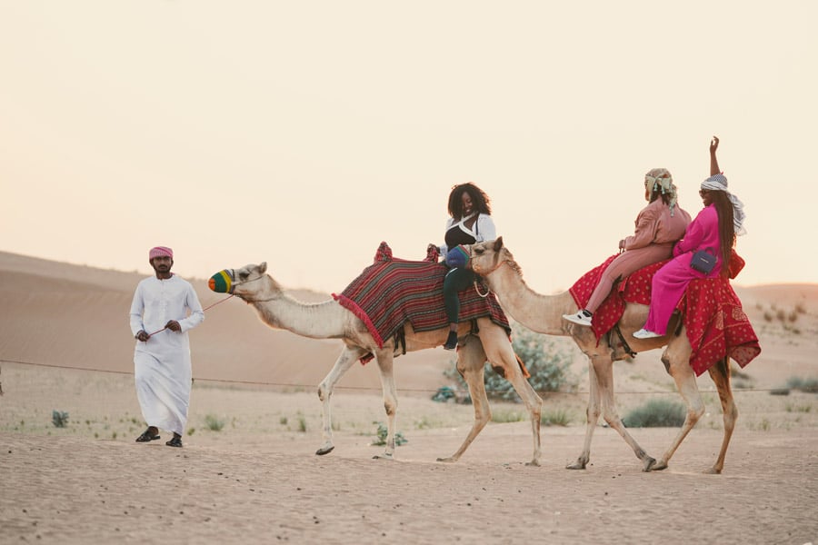 Touriste montant à dos de chameau à Dubaï